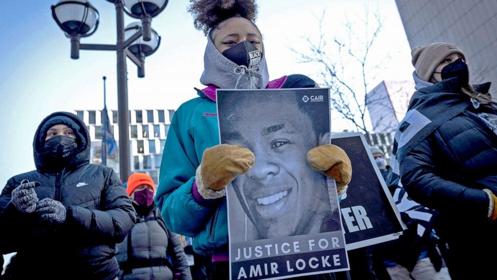 PHOTO: Demonstrators hold placards during a rally in protest of the killing of Amir Locke, outside the Hennepin County Government Center in Minneapolis, Minnesota on February 5, 2022.