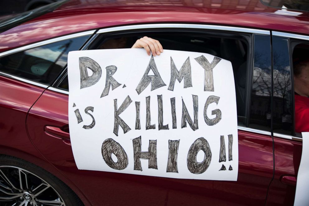 PHOTO: A protester holds up a sign against Dr. Amy Acton outside of the Ohio State House in Columbus, Ohio, on April 18, 2020.