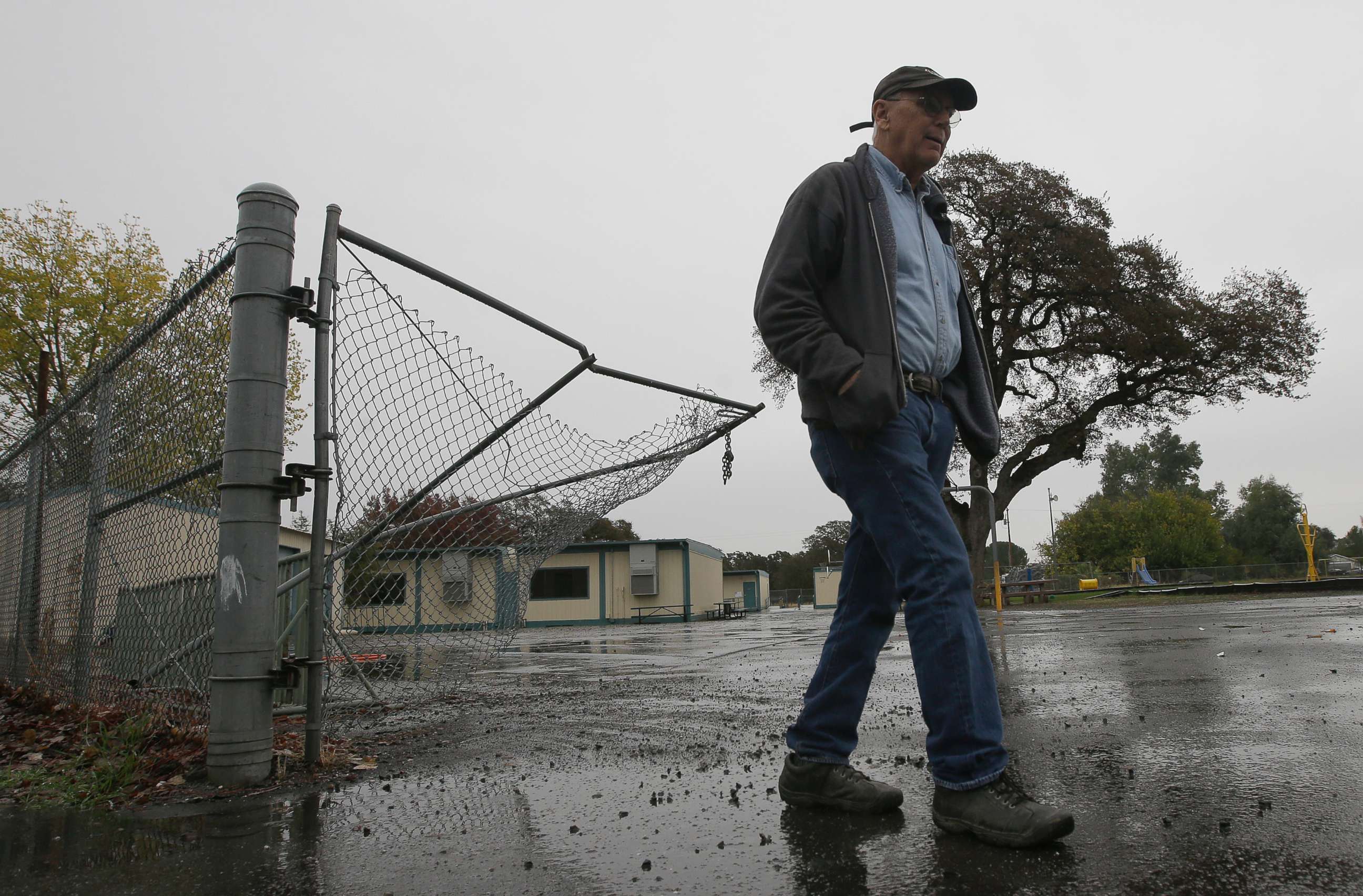 PHOTO: Randy Morehouse, the maintenance and operations supervisor for the Corning Elementary School District, walks past the gate that gunman Kevin Janson Neal crashed through during his shooting rampage at Rancho Tehama Elementary School, Nov. 15, 2017.