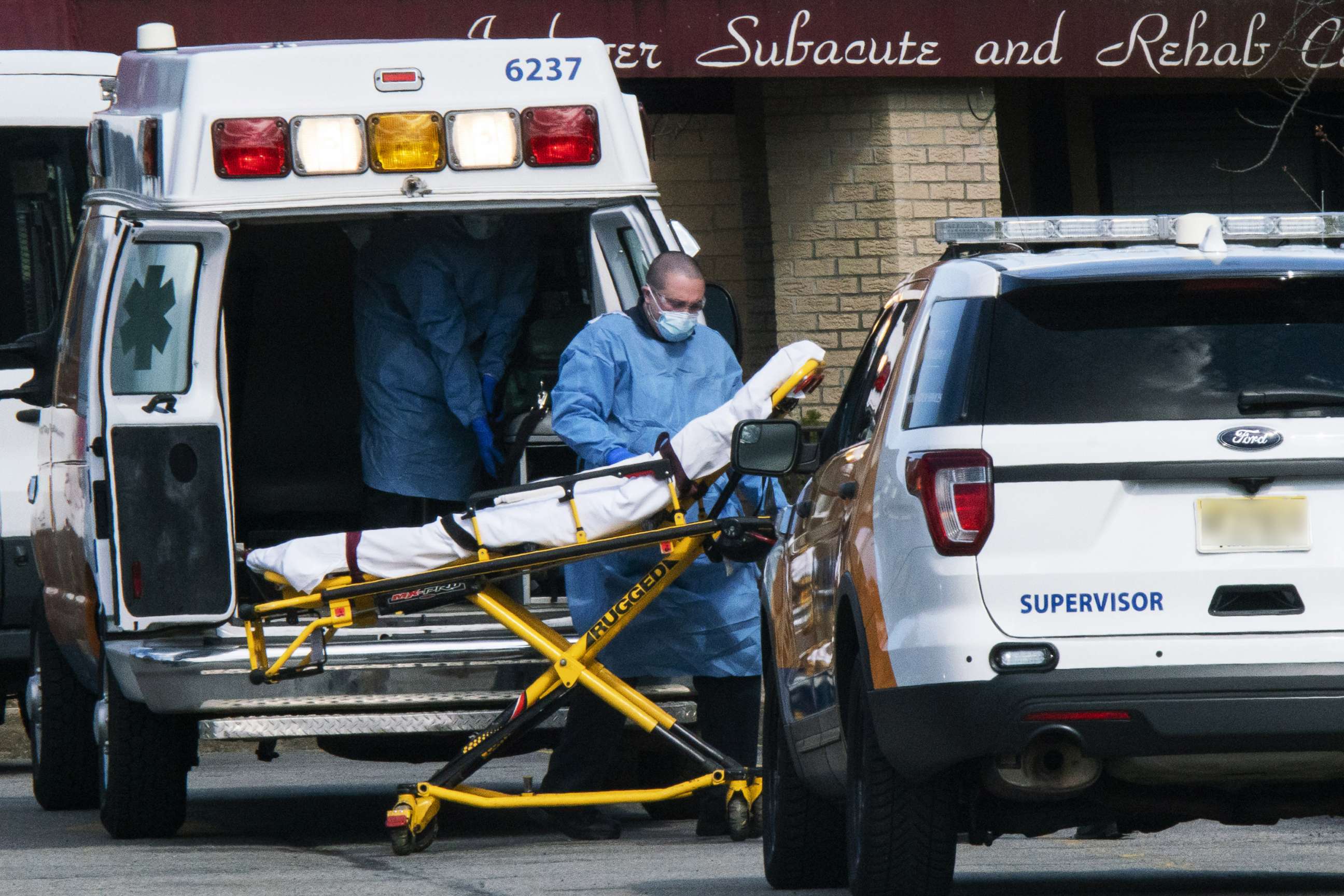 PHOTO: Medical workers prepare to transport a patient from Andover Subacute and Rehabilitation Center while wearing masks and personal protective equipment (PPE),  April 16, 2020 in Andover, New Jersey.