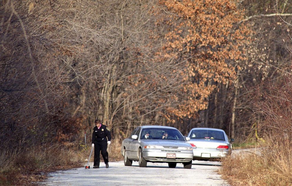 PHOTO: Police detectives and sheriff's deputies near the scene in St. Charles County, Mo., where a body believed to be Angie Housman's was found on Nov. 27, 1993. 