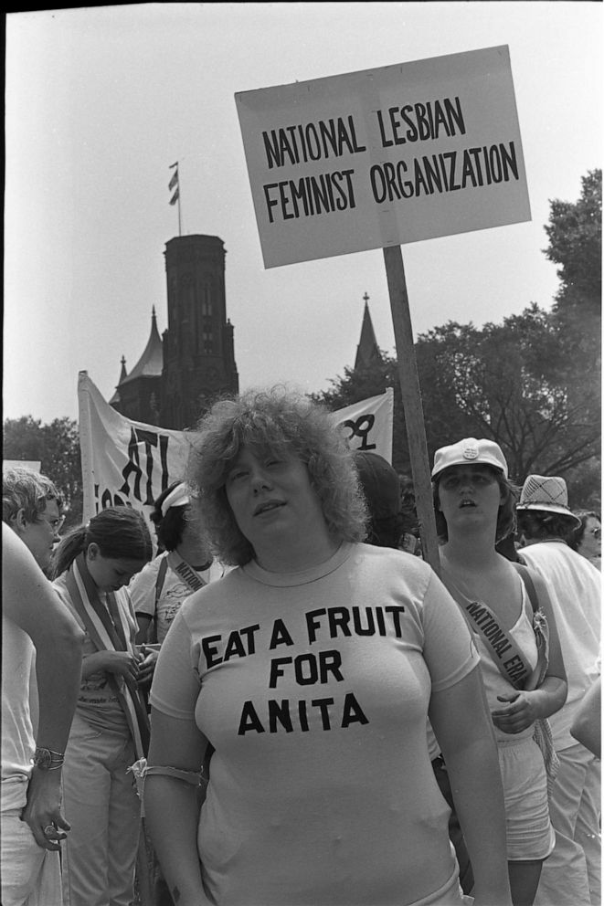 PHOTO: Portrait of a woman as she stands under a 'National Lesbian Feminist Organization' sign on the National Mall prior to the Equal Rights Amendment March, Washington DC, July 9, 1978.