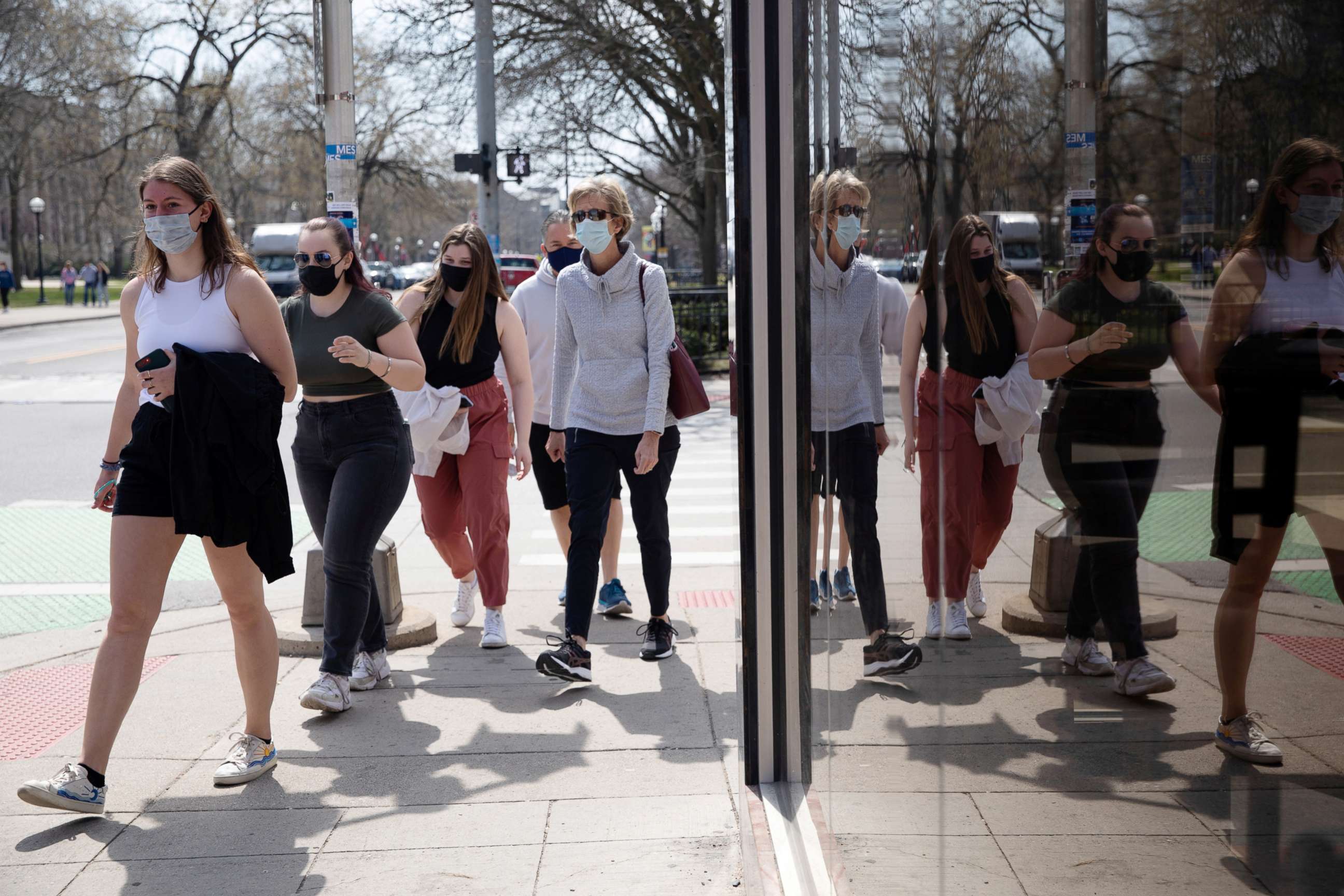 PHOTO: A group of people walk wearing protective masks head to a restaurant as COVID-19 restrictions are eased in Ann Arbor, Mich., on April 4, 2021.
