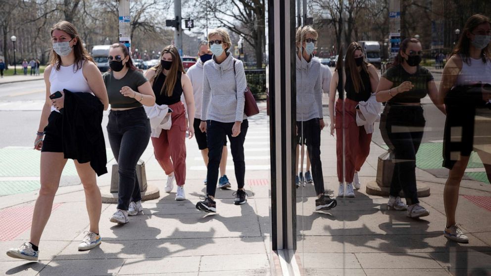 PHOTO: A group of people walk wearing protective masks head to a restaurant as COVID-19 restrictions are eased in Ann Arbor, Mich., on April 4, 2021.