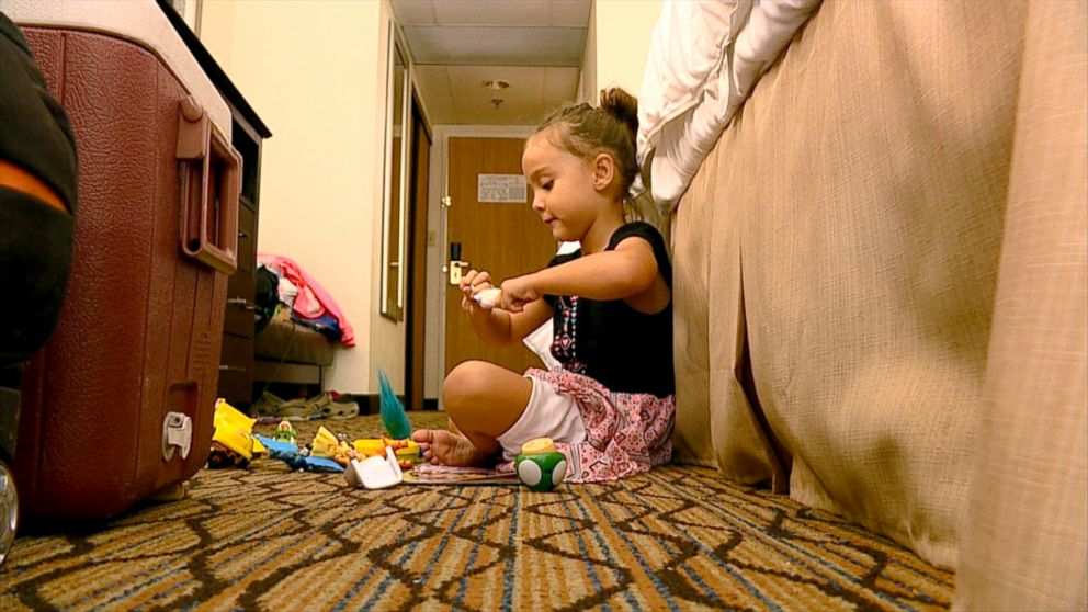 PHOTO: Annabella Weeks, 5, plays with toys on the floor of her hotel room while her parents apply for FEMA disaster assistance.