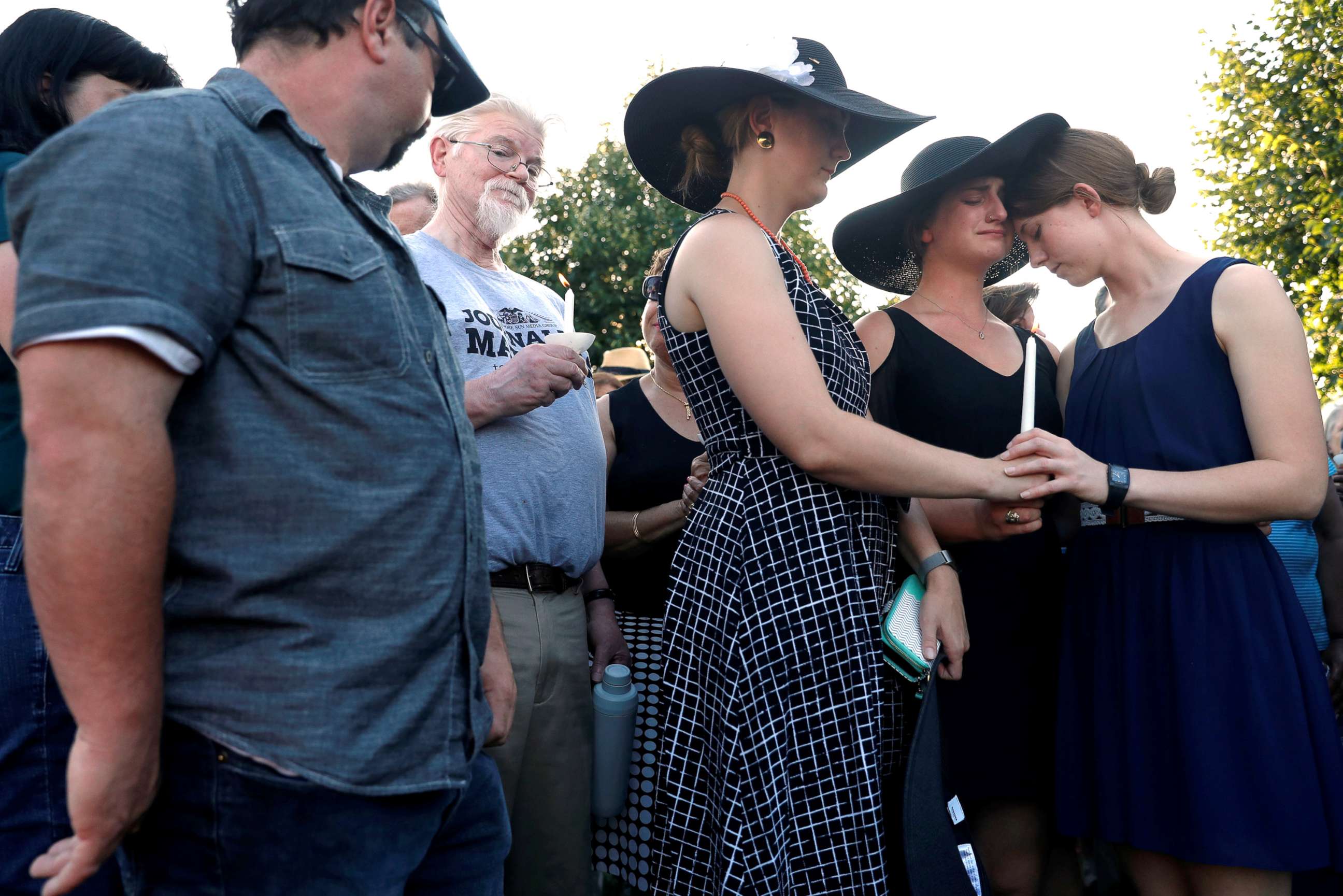 PHOTO: Three daughters of Wendi Winters, Winters, Summerleigh and Montana Geimer hold each other during a candlelight vigil held near the Capital Gazette in Annapolis, Md., June 29, 2018.