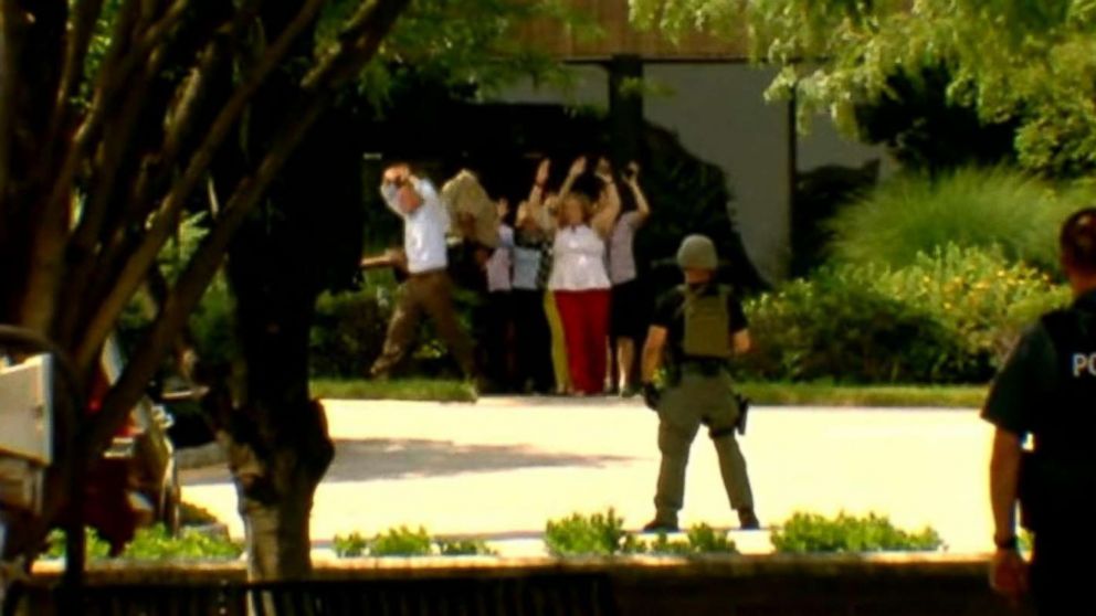 PHOTO: People walk out of a building with their hands up in Annapolis, Md., after reports of a shooting, June 28, 2018.