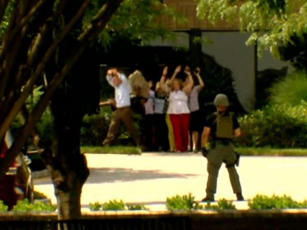 PHOTO: People walk out of a building with their hands up in Annapolis, Md., after reports of a shooting, June 28, 2018.