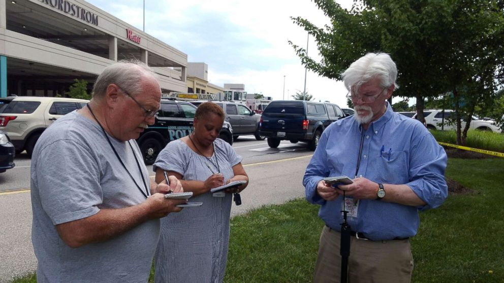 PHOTO: Capital Gazette journalist E.B. "Pat" Furgurson III takes notes with two other people as police officers respond to a shooting inside Capital Gazette offices in Annapolis, Md., June 28, 2018.