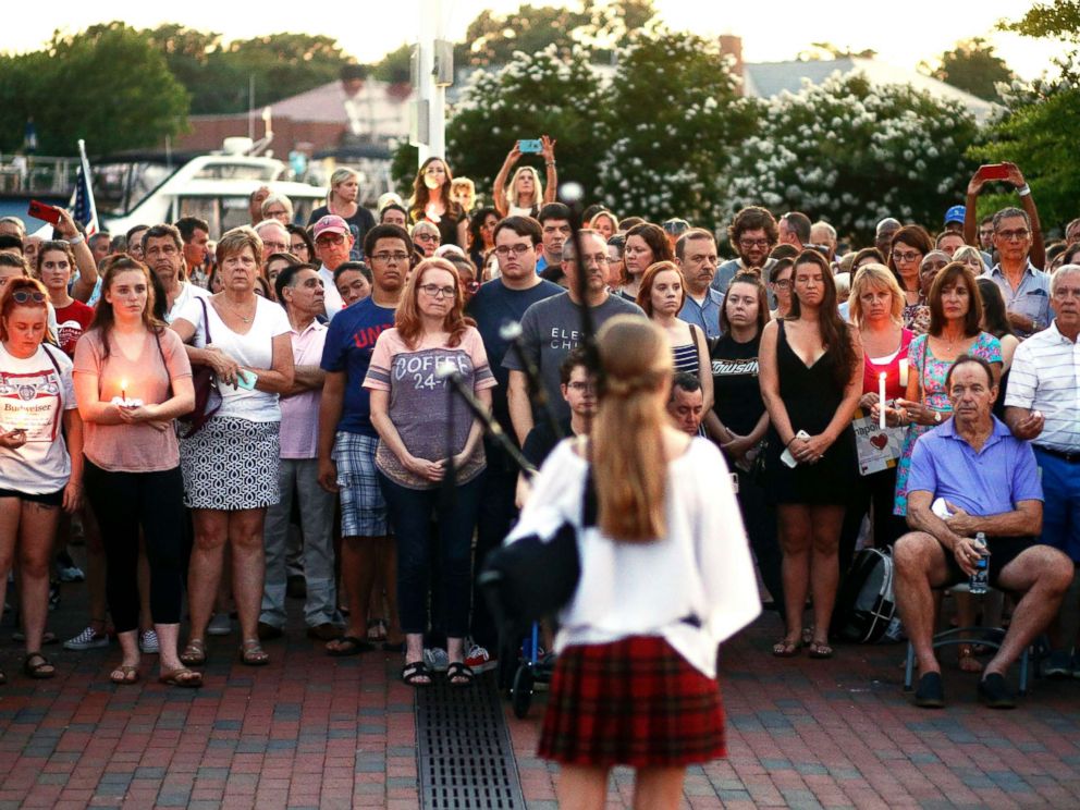 PHOTO: People listen to a bagpipe player during a vigil in response to a shooting in the Capital Gazette newspaper office on June 29, 2018, in Annapolis, Md.
