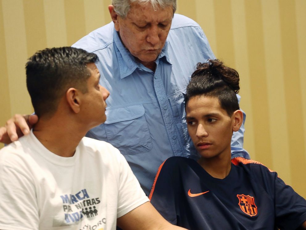 Anthony Borges, right, and his father, Roger, left, listen to his grandfather Alfredo during a news conference in Plantation, Fla., Friday, April 6, 2018.