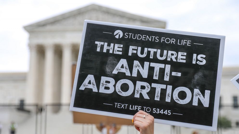 PHOTO: Protesters from both sides of the abortion debate wave competing scripture interpretations during a rally outside the Supreme Court, June 21, 2022. 