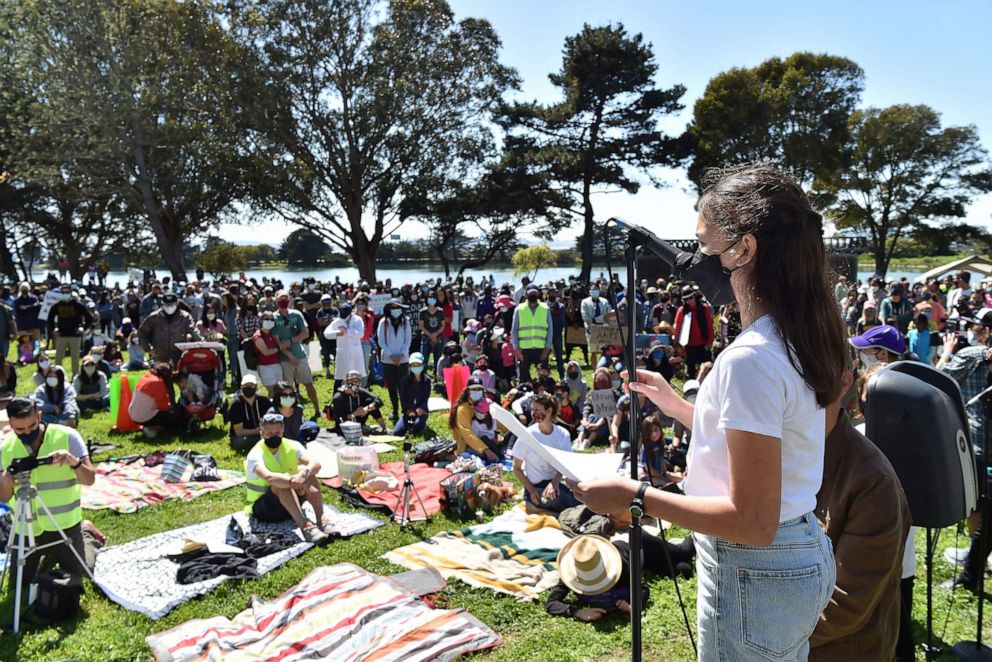 PHOTO: Event organizer Mina Fedor speaks to attendees during a rally in solidarity with Asian Americans and Pacific Islanders held at the Berkeley Aquatic Park, in Berkeley, Calif.,  March 28, 2021. 