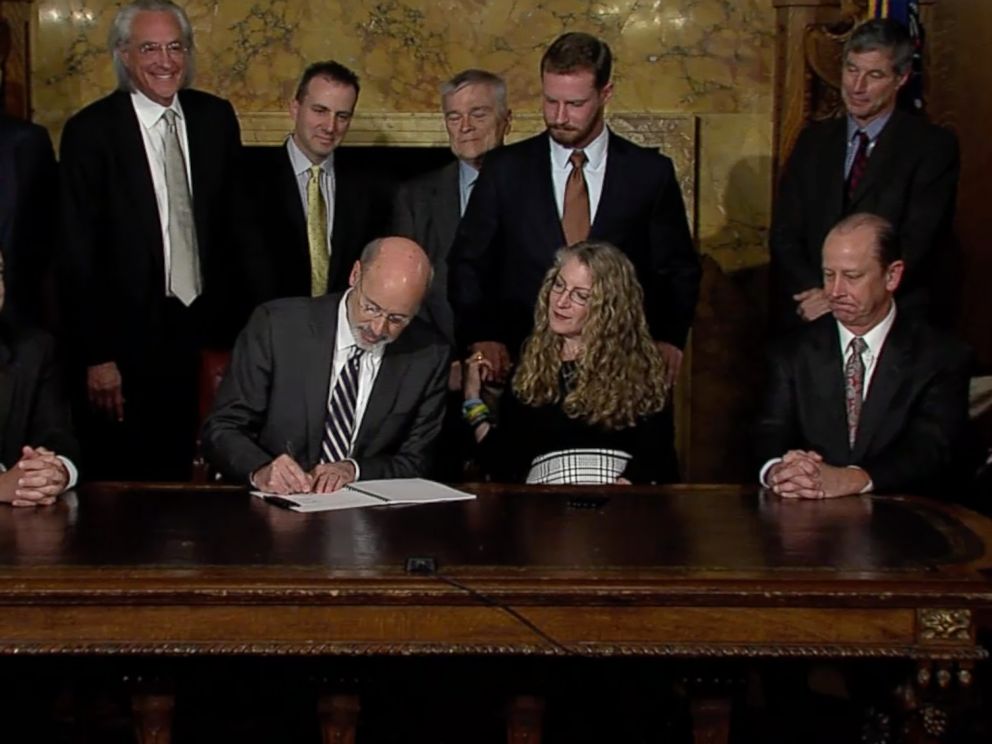 PHOTO: Pennsylvania Governor Tom Wolf signs anti-hazing law surrounded by lawmakers and Tim Piazza's family.
