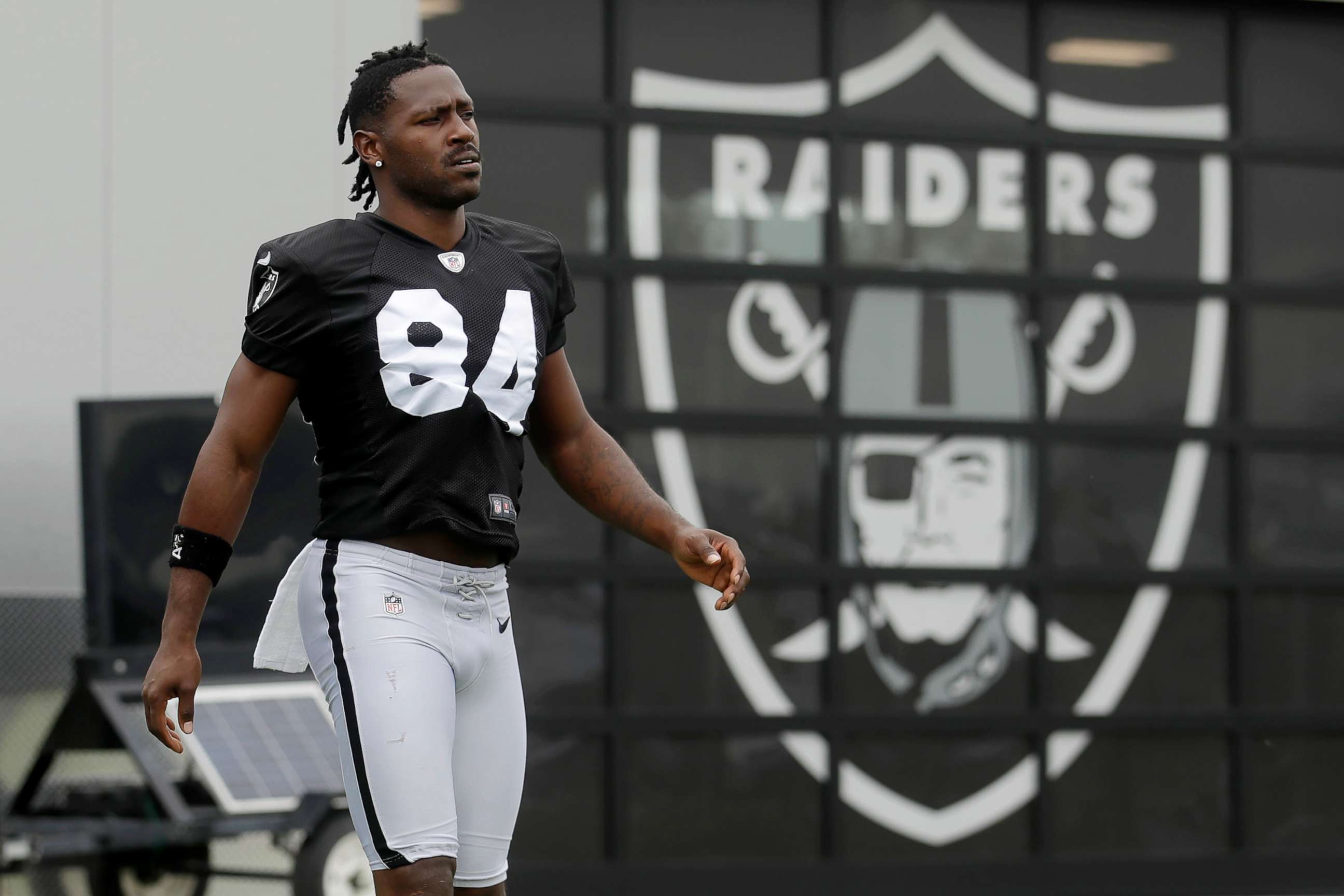PHOTO: Oakland Raiders' Antonio Brown walks on the field while stretching during NFL football practice in Alameda, Calif., Aug. 20, 2019.