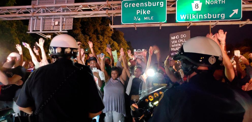 PHOTO: Protesters chant "Hands up! Don't shoot!" at motorcycle officers near the head of a line of vehicles stuck on Interstate 376 in Pittsburgh, June 21, 2018 for the death of Antwon Rose.