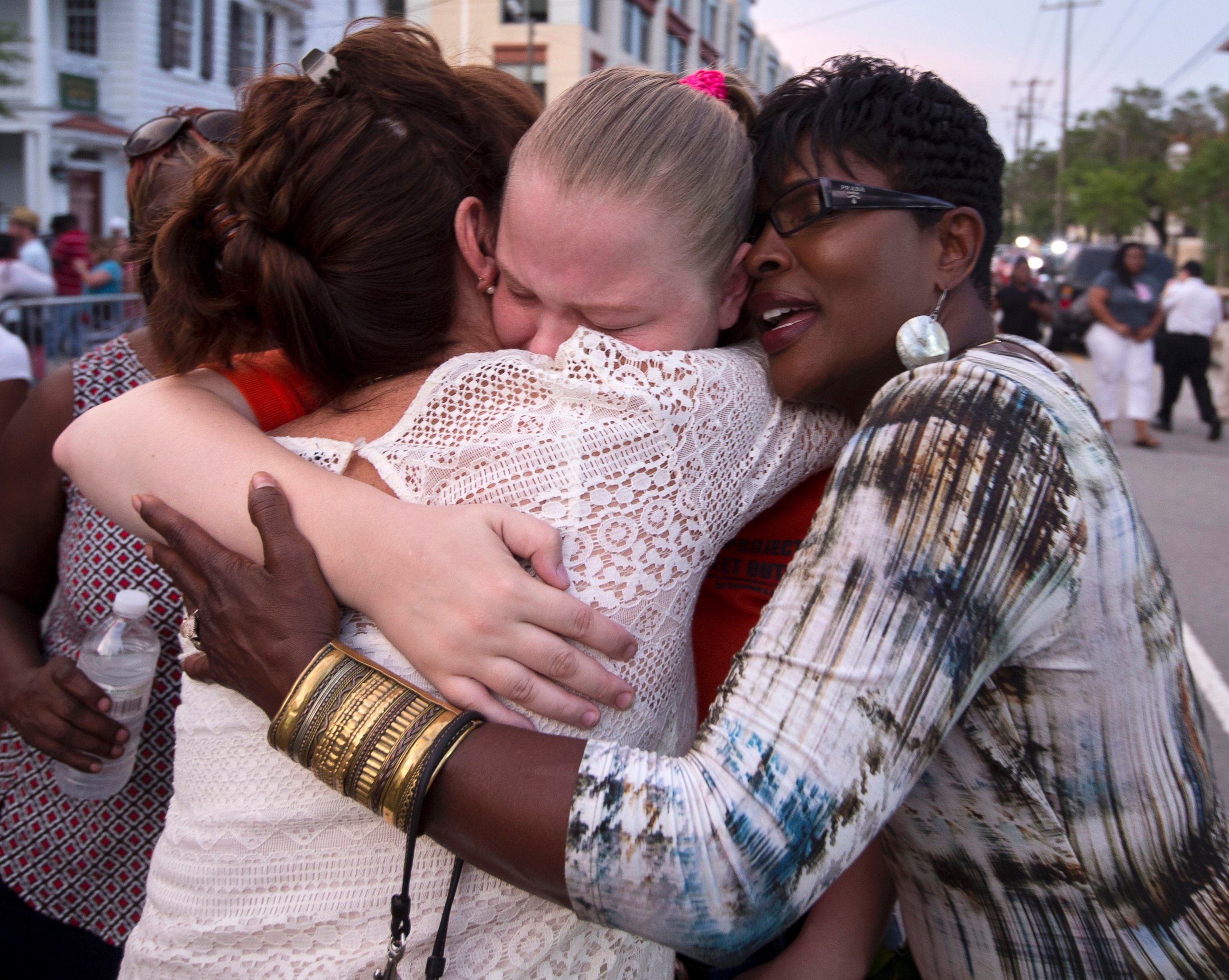 PHOTO: J. Denise Cromwell, left, hugs her daughter, Asia Cromwell, center, and a friend Sandy Teckledburg outside the Emanuel AME Church after a memorial in Charleston, S.C., June 19, 2015.