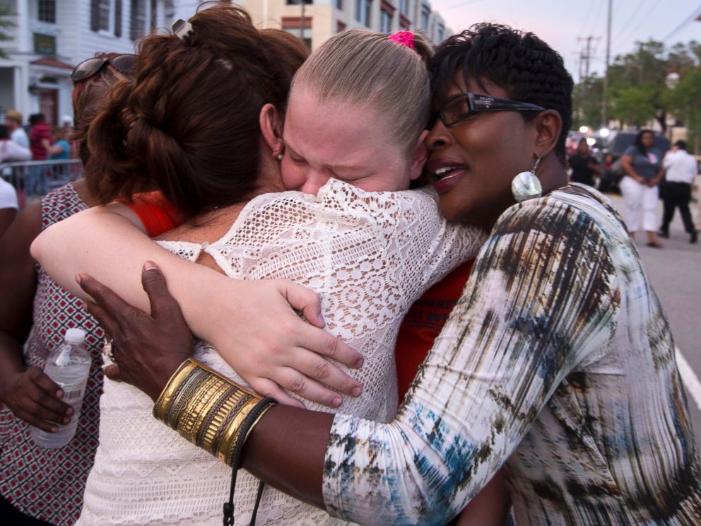 PHOTO: J. Denise Cromwell, left, hugs her daughter, Asia Cromwell, center, and a friend Sandy Teckledburg outside the Emanuel AME Church after a memorial in Charleston, S.C., June 19, 2015.