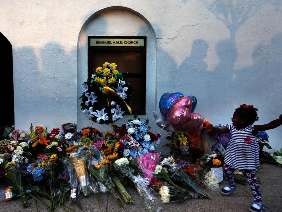 PHOTO: Mourners pass by a make-shift memorial on the sidewalk in front of the Emanuel AME Church following a shooting by Dylann Roof in Charleston, S.C., June 18, 2015.