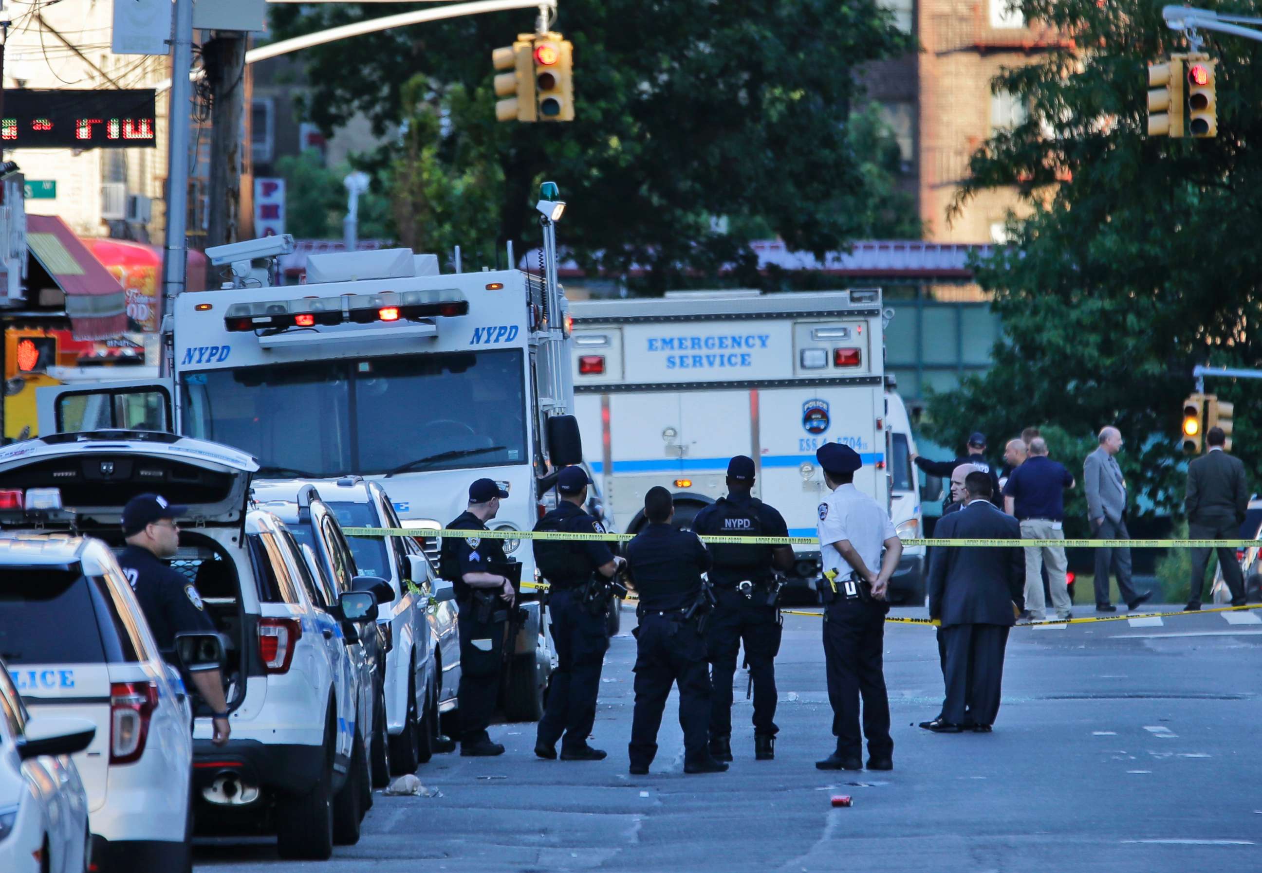 PHOTO: Emergency personnel stand near the scene where a police officer was fatally shot while sitting in her patrol car in the Bronx section of New York, July 5, 2017. 