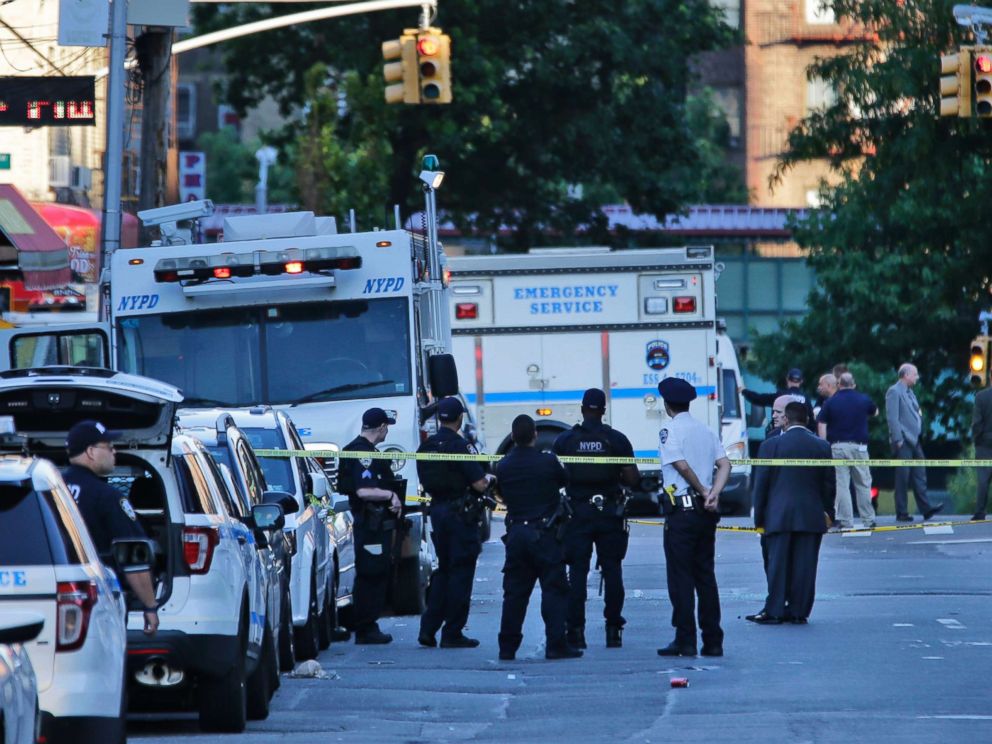 PHOTO: Emergency personnel stand near the scene where a police officer was fatally shot while sitting in her patrol car in the Bronx section of New York, July 5, 2017.