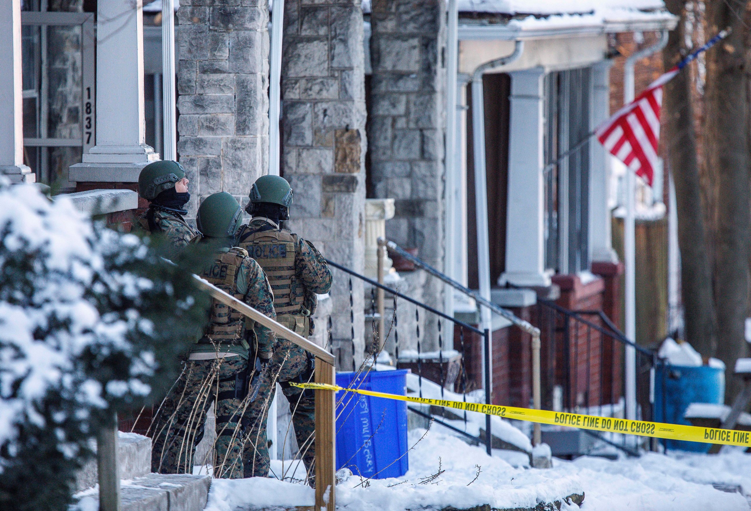 Police stand outside a residence where a gunman opened fire on law enforcement officers serving an arrest warrant inside earlier Thursday, Jan. 18, 2018, in Harrisburg, Pa. 