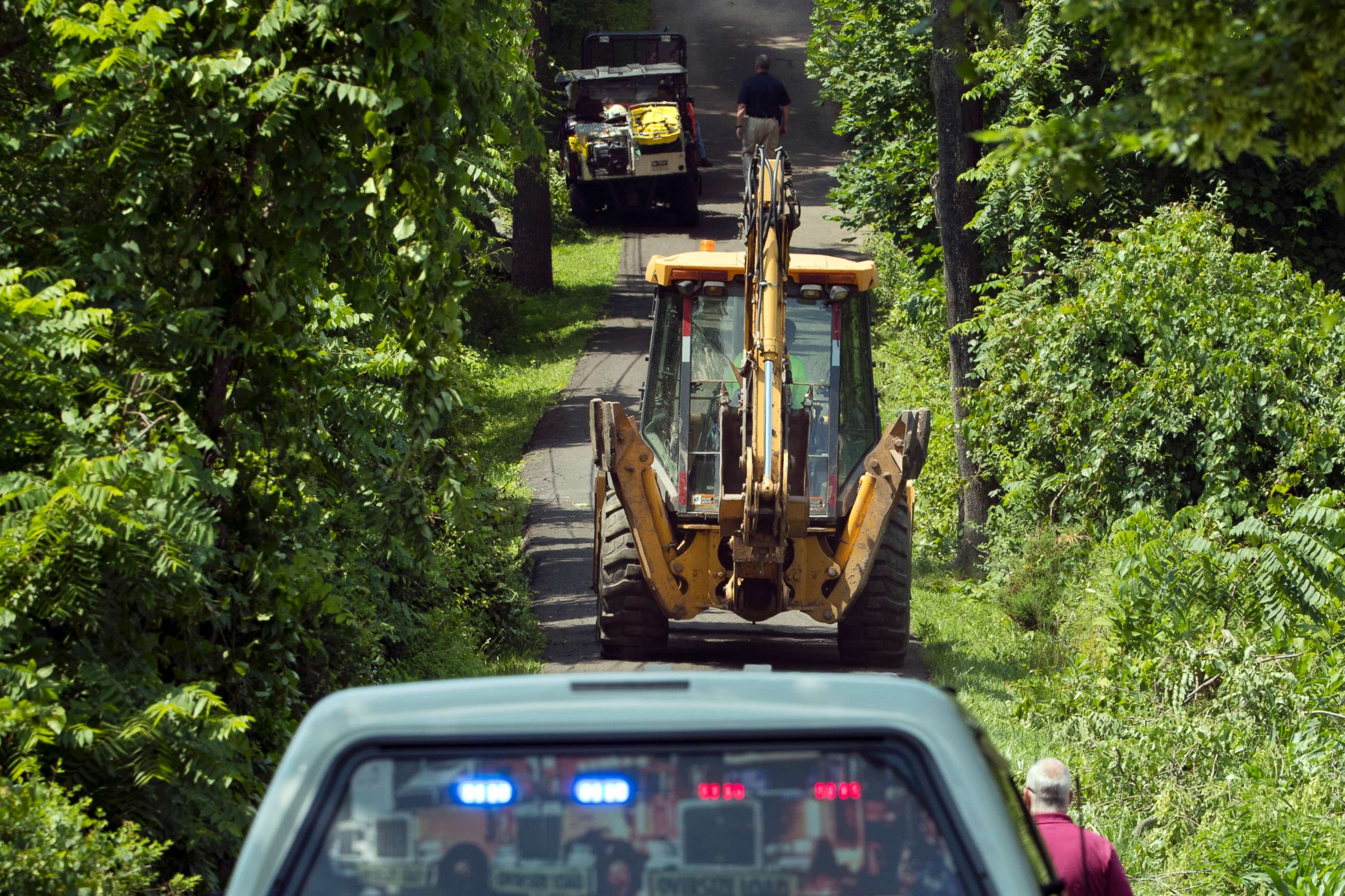 PHOTO: Construction equipment and law enforcement officials head down a blocked off drive way, July 10, 2017, in Solebury, Pa.