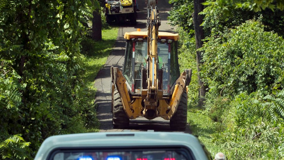 PHOTO: Construction equipment and law enforcement officials head down a blocked off drive way, July 10, 2017, in Solebury, Pa.