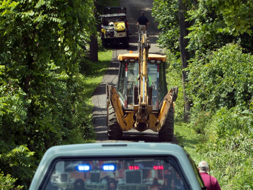 PHOTO: Construction equipment and law enforcement officials head down a blocked off drive way, July 10, 2017, in Solebury, Pa.