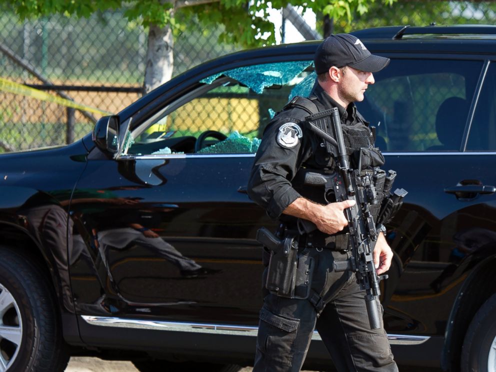 PHOTO: A Capitol Hill Police officer walks past an automobile with the drivers window damaged at the scene of a shooting in Alexandria, Va., June 14, 2017, where House Majority Whip Steve Scalise of La. was shot at a Congressional baseball practice.