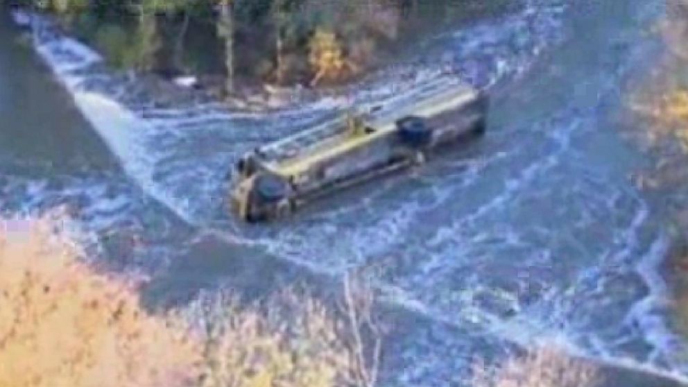 This image provided by KAKE-TV shows a school bus after it toppled into a creek, Thursday, Oct. 31, 2013 in Douglass, Kan. Ten Kansas children and a school bus driver were pulled to safety from a fast-moving creek Thursday after the bus toppled into the water and landed half-submerged on its side.