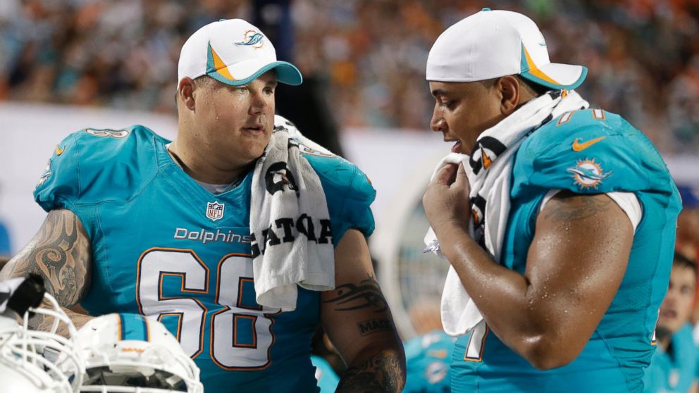 Miami Dolphins' Richie Incognito (68) and Jonathan Martin (71) look over plays during the second half of an NFL preseason football game against the Tampa Bay Buccaneers, Aug. 24, 2013, in Miami Gardens, Fla.