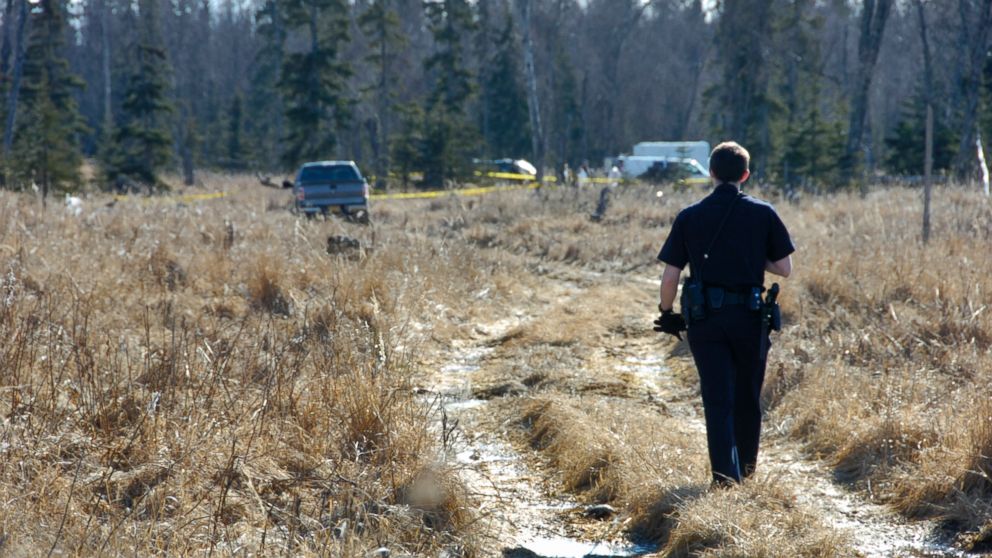 PHOTO: On March 22, 2015, a Kenai police officer walks down a trail leading to a temporary camp where police and Federal Bureau of Investigations personnel are working to identify human remains.