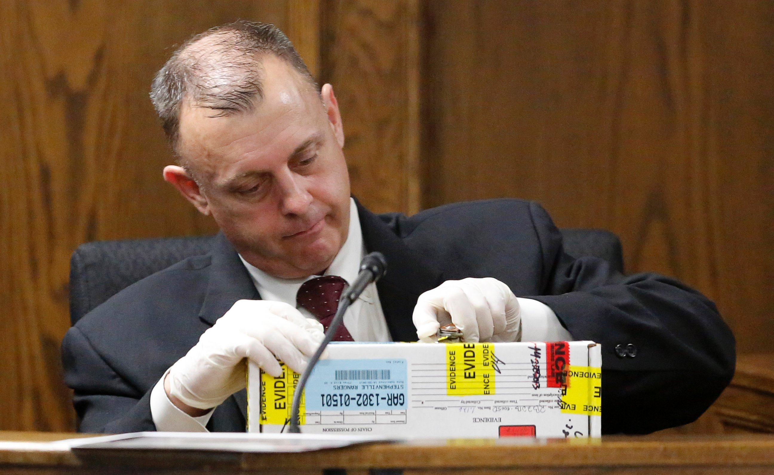 PHOTO: Texas Ranger Michael Adcock opens boxed evidence as he testifies during the second day of former Marine Cpl. Eddie Ray Routh's capital murder trial in Stephenville, Texas, Thursday, Feb. 12, 2015. 