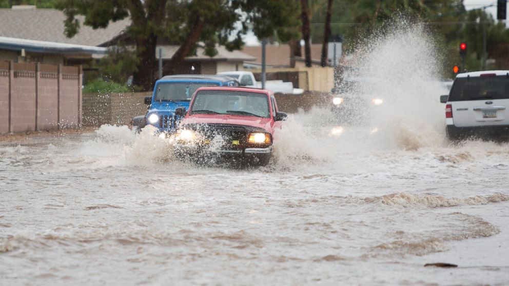 Vehicles drive through the flood prone area of 39th Avenue between Peoria Avenue and Cactus Road during a storm in Phoenix on Saturday, Sept. 27, 2014.