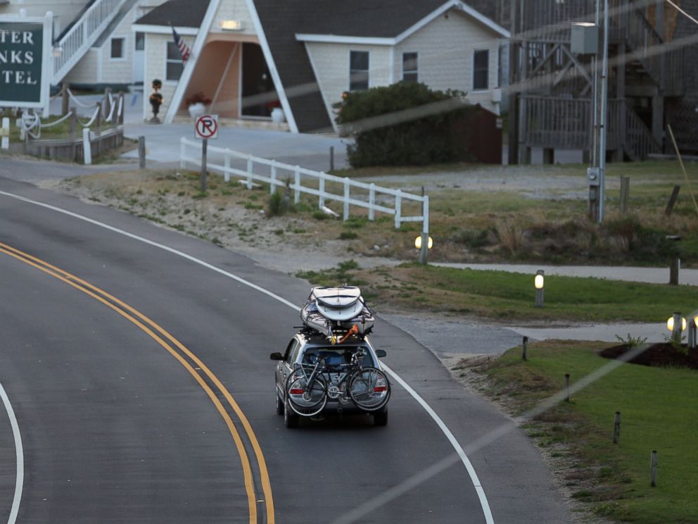 PHOTO: A car loaded down with bikes, kayaks and surfboards heads north on NC 12 through Buxton on Hatteras Island, N.C., July 3, 2014.