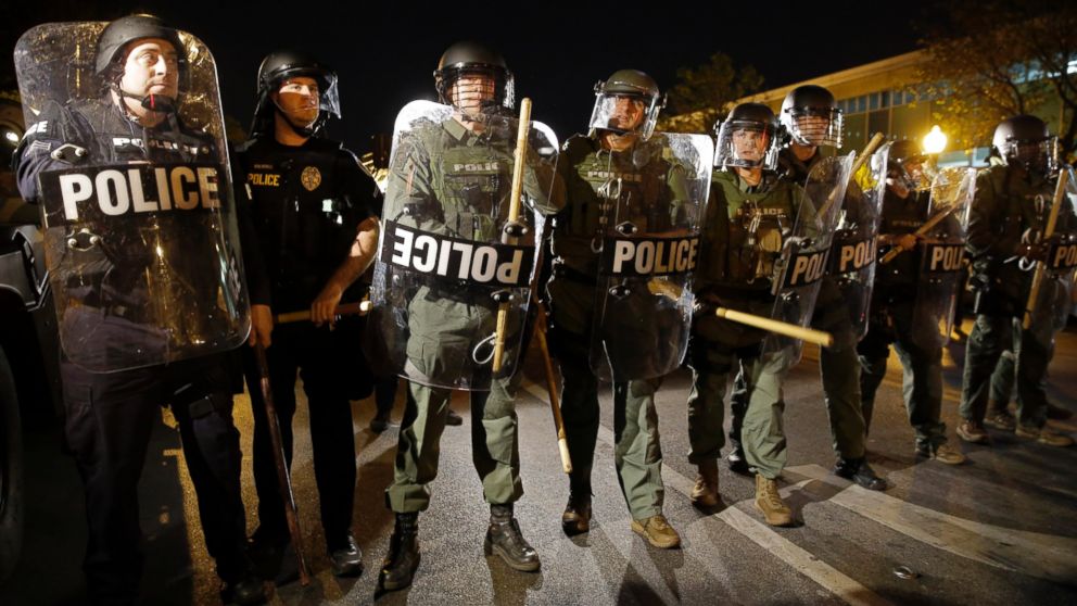 In this April 29, 2015 file photo, police stand in formation as a curfew approaches for the second night in a row in Baltimore.