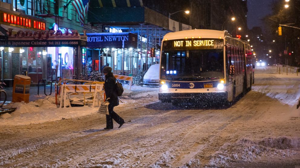 A person crosses a snow-covered Broadway in the Upper West Side neighborhood of New York, Monday, Jan. 26, 2015. People in the Northeast by the thousands left work early as the region started to shut down in the face of a snowstorm that could be one for the history books, with some 35 million people in its path in the Philadelphia-to-Boston corridor.