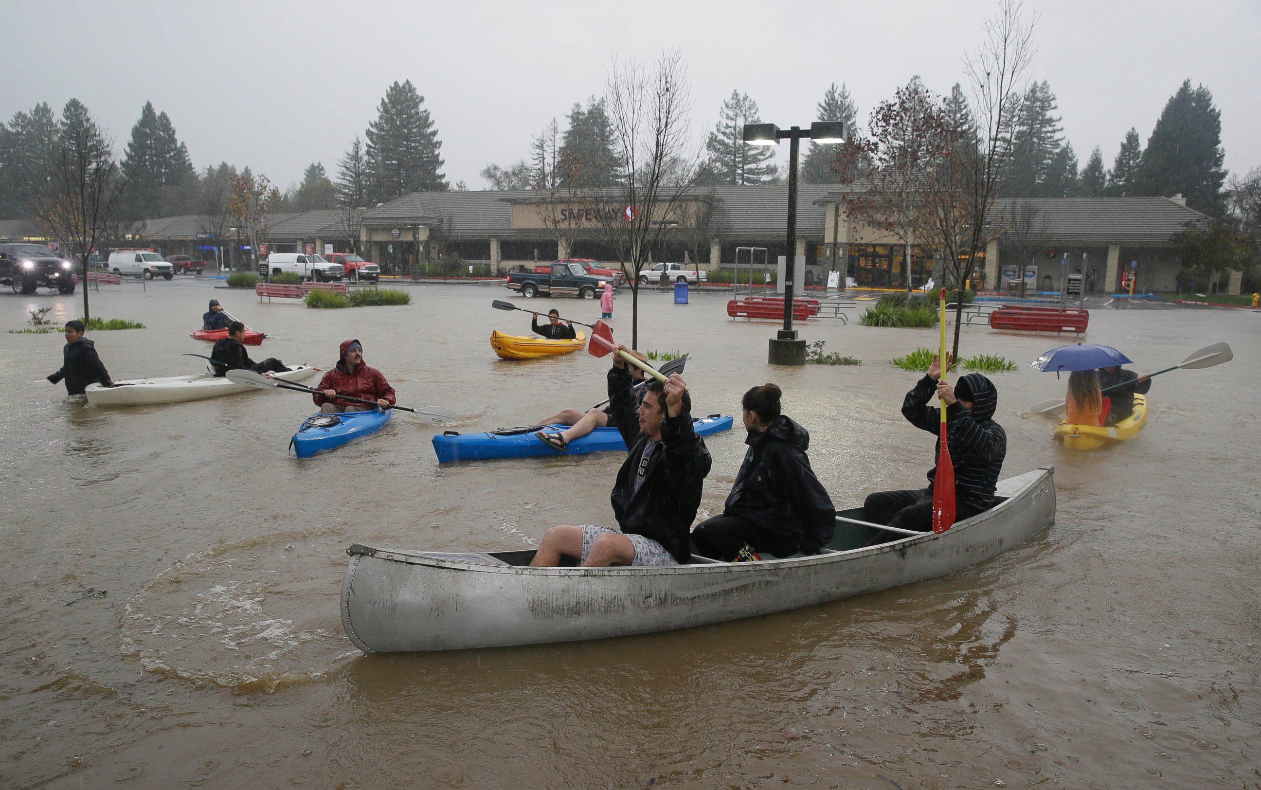 PHOTO: People use kayaks and a canoe to make their way around a flooded parking lot at a shopping center in Healdsburg, Calif., Dec. 11, 2014.
