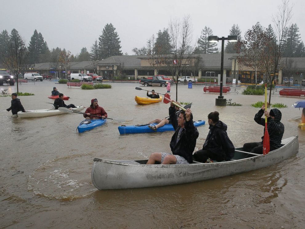 PHOTO: People use kayaks and a canoe to make their way around a flooded parking lot at a shopping center in Healdsburg, Calif., Dec. 11, 2014.