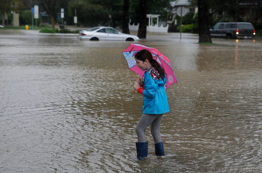PHOTO: Hailey Thistle, 8, walks into a flooded parking lot at a shopping center in Healdsburg, Calif., Dec. 11, 2014.