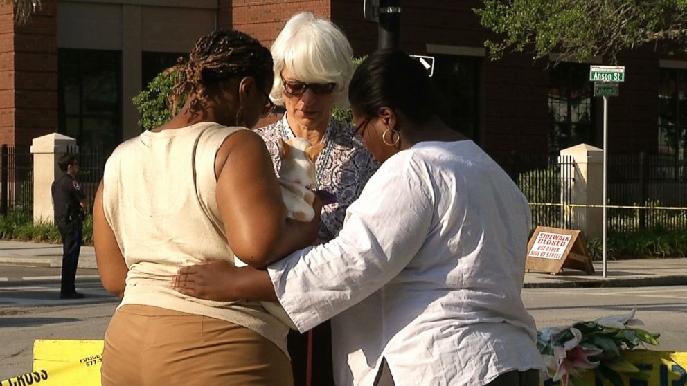 In this image taken from video on June 18, 2015, Tarsha Moseley, left, Martha Watson, and Toby Smith pray at a makeshift memorial near Emanuel AME Church in Charleston, S.C. 