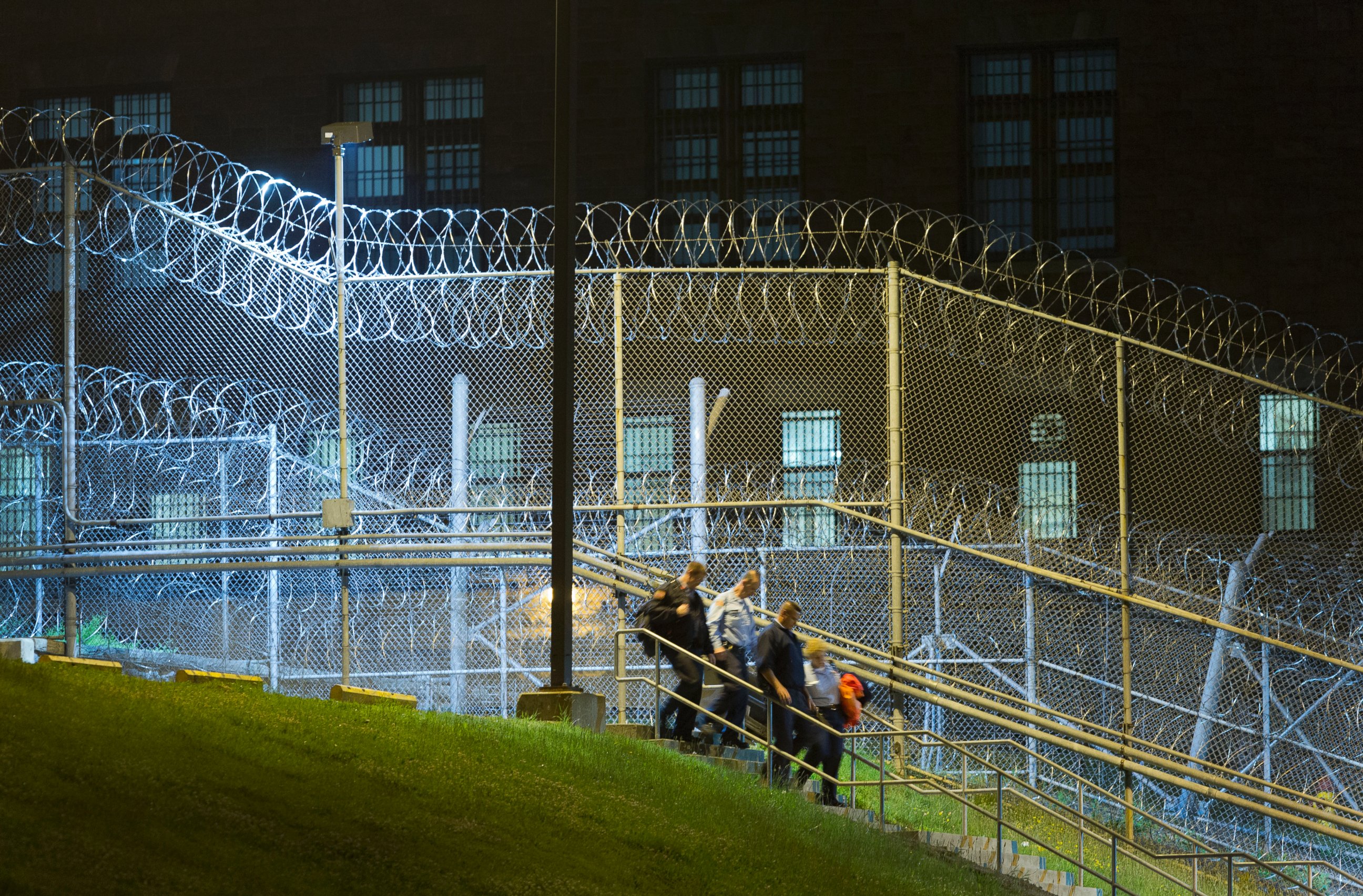 PHOTO: Corrections officers walk next to a fence covered in razor wire as they leave work at Clinton Correctional Facility in Dannemora, N.Y., June 15, 2015.