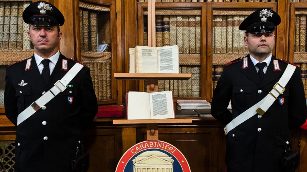 Italian Carabinieri officers stand by a reprinted copy of Christopher Columbus original letter written in 1493 about the discovery of the New World, on the stand below, and a fake of the reprinted copy, above, during a press conference in Rome, May 18, 2016.