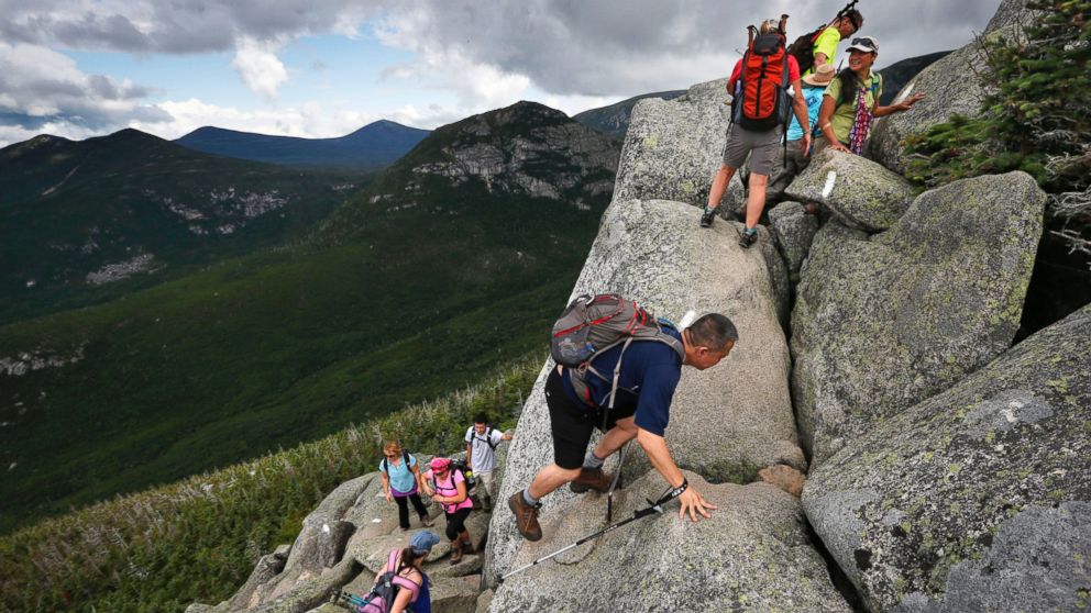 In this Saturday, Aug. 7, 2015 photo, day-hikers scramble over rocky boulders on the Appalachian Trail below the summit of Mt. Katahdin in Baxter State Park in Maine.