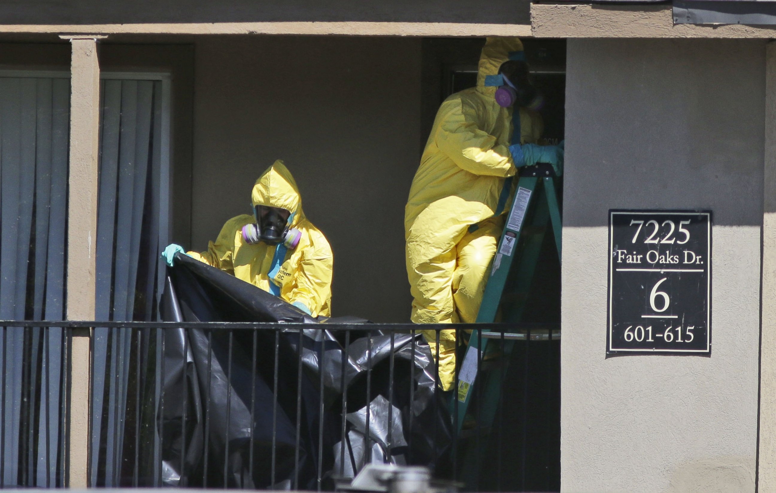 PHOTO: Hazardous material cleaners prepare to hang black plastic outside the apartment in Dallas where Thomas Eric Duncan, the Ebola patient who traveled from Liberia to Dallas stayed last week, Oct. 3, 2014.