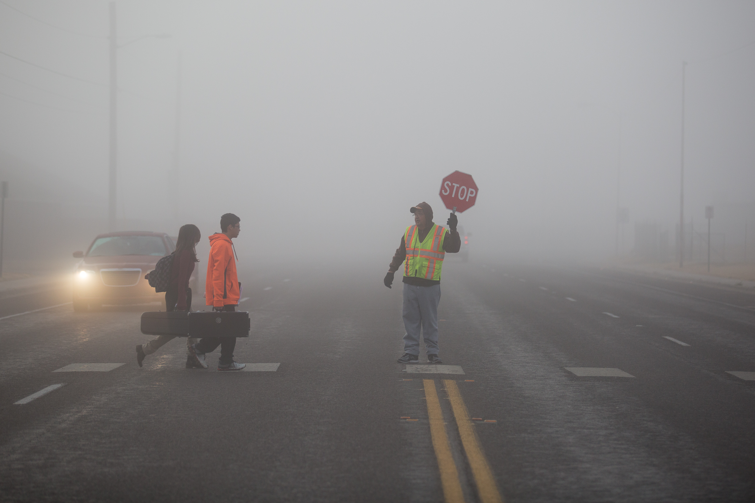 PHOTO: A crossing-guard stops traffic along Rainbow Drive as students cross the street during heavy fog in Odessa, Texas on Tuesday, Dec. 9, 2014.