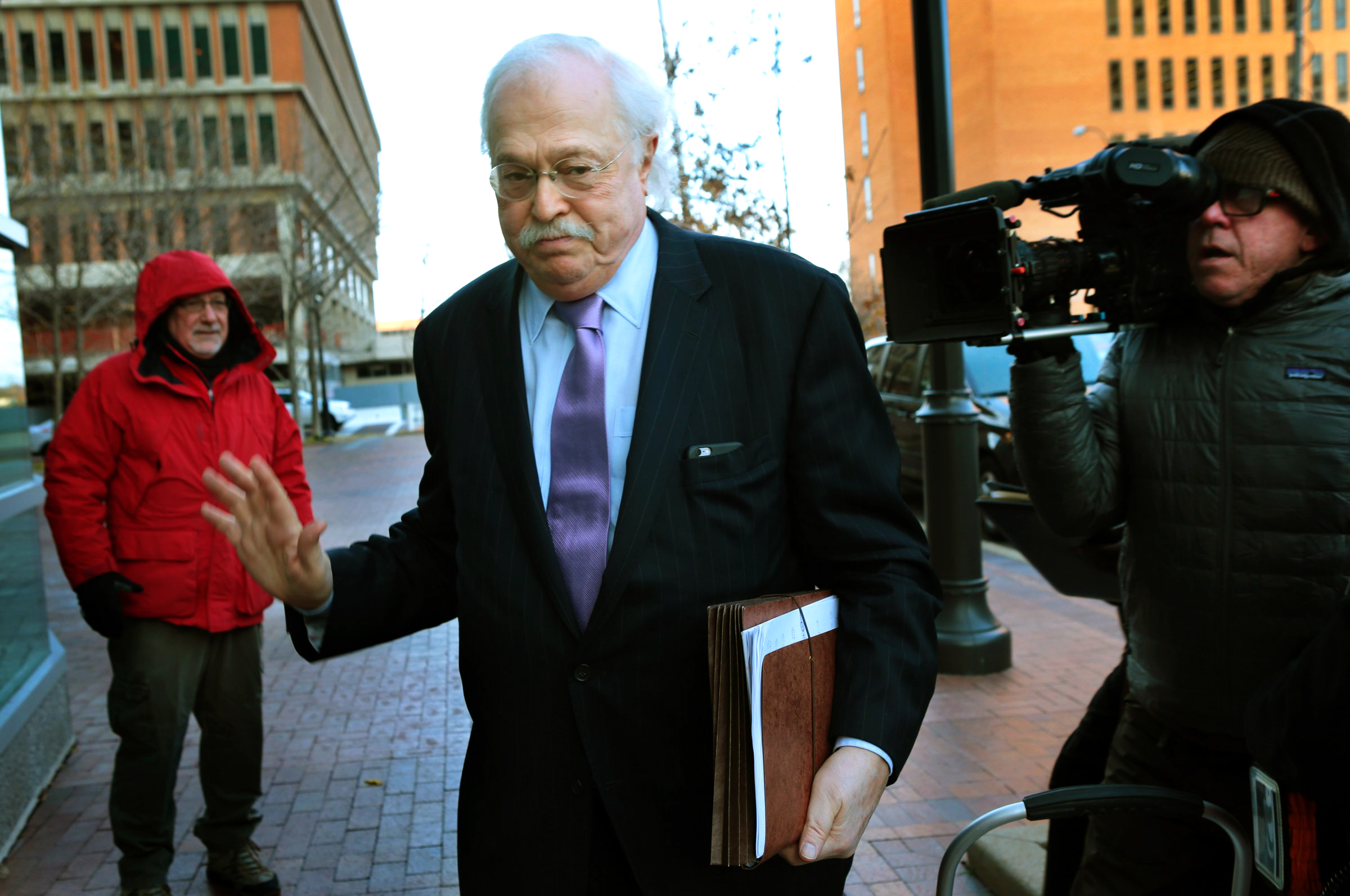 PHOTO: Pathologist Dr. Michael Baden waves off media questions as he arrives to testify before the grand jury concerning the Michael Brown shooting at the Buzz Westfall Justice Center in Clayton, Mo., on Nov. 13, 2014.