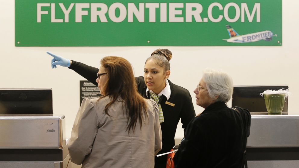 PHOTO: A Frontier Airlines employee wears rubber gloves as she directs passengers where to go at Cleveland Hopkins International Airport, Oct. 15, 2014, in Cleveland. 