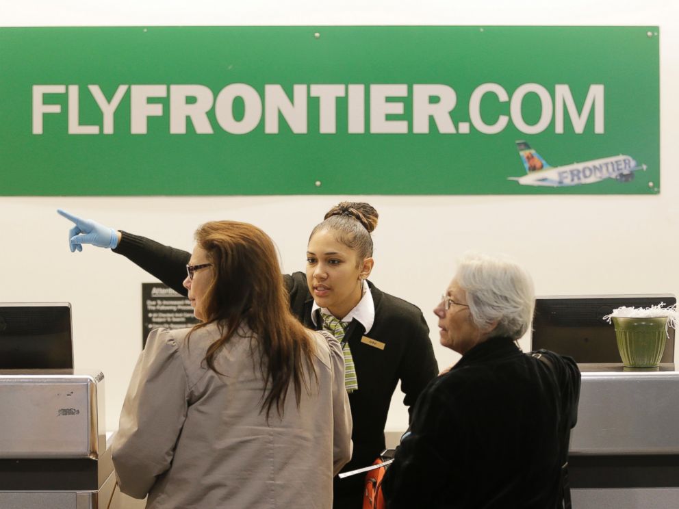 PHOTO: A Frontier Airlines employee wears rubber gloves as she directs passengers where to go at Cleveland Hopkins International Airport, Oct. 15, 2014, in Cleveland.